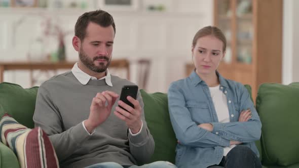 Man Busy with Smartphone Sitting Next to Angry Wife Woman alt