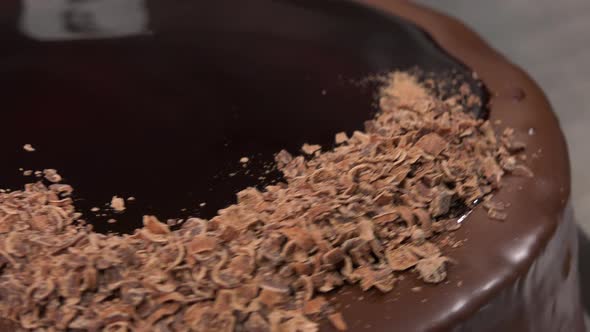 Grated Chocolate Is Spread Over the Top of a Chocolate Cake - Closeup alt