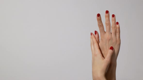 Beautiful Woman's Hands with Bright Red Manicure, One Hand Gently Massaging the Other alt