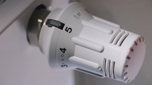 The Homeowner Adjusts the Temperature in the House on a Thermostat alt