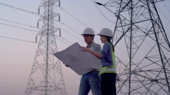 Two specialist electrical engineer working near to High voltage tower.