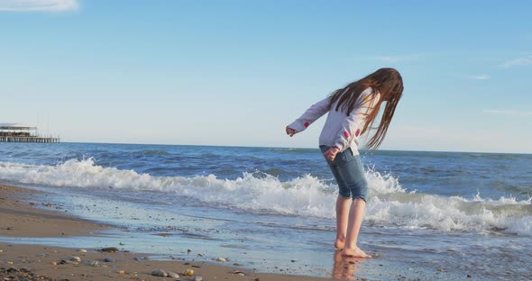 Little Girl Playing on the Beach in Summer