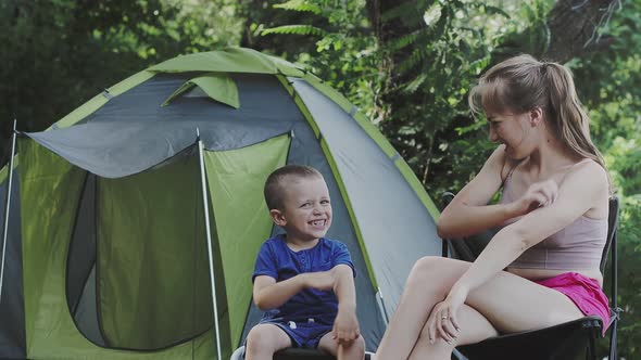 Mom and her son to itching after mosquito bites sitiing near tent. alt