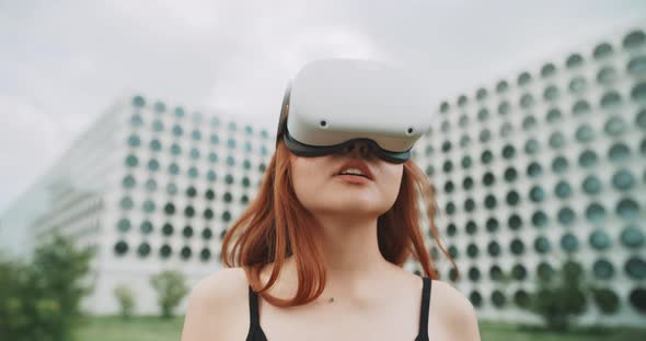 A woman moving her head while using augmented reality goggles alt