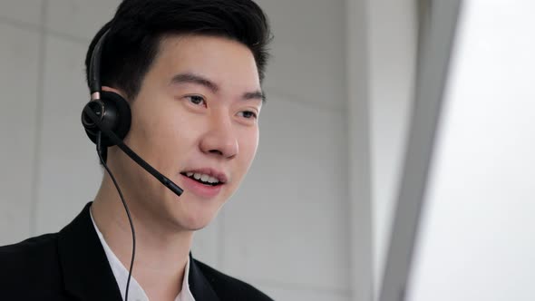 smart guy call center wear headset and working with computer while consulting customer alt