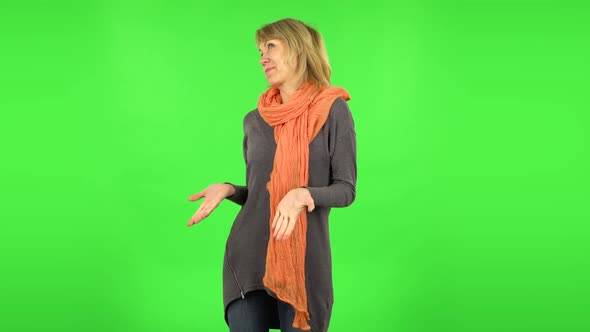 Middle Aged Blonde Woman Is Surprised at What Is Happening Around. Green Screen alt