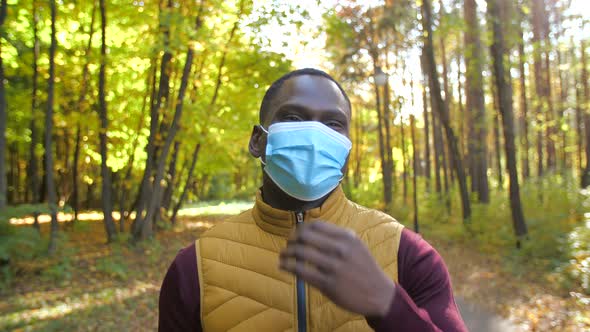 The End of the Pandemic. Stop Quarantine Concept. A Happy Young African Man Takes Off His Protective alt