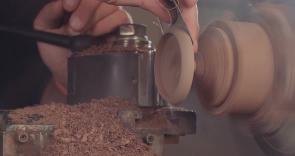 Artist creating a buddhist prayer wheel on a lathe alt