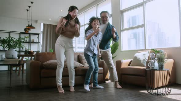 happiness asian family dance along together at home in living room,