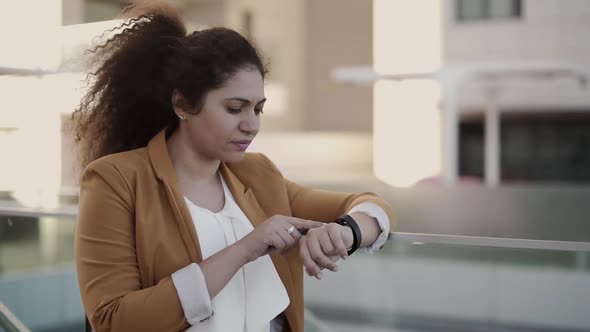 Fashionable Businesswoman Using Smartwatch and Replying To Message Online