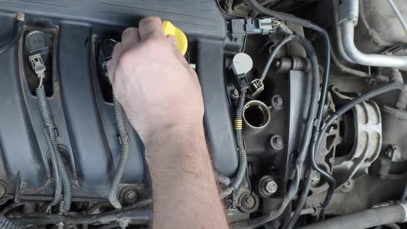 Closeup Video of a Male Hand Pouring an Oil Into a Car Engine