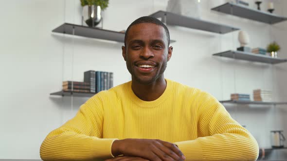 Smiling man looking at laptop by video link in office alt
