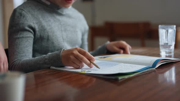 Focused Shot of a Male Child's Body with an Open Textbook While Homeschooling alt