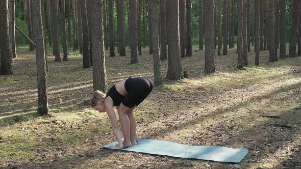 Flexible Fit Female Practices Yoga Performs Surya Namaskar at Sunny Pine Forest