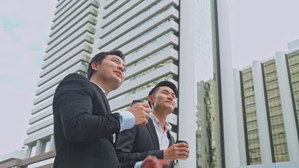 Asian young friend office business people hold cup of coffee and walk outdoor in city with confident alt