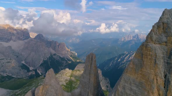 Slow tilt down aerial above Tre Cime South Tyrol extreme valley mountain summit rock formation alt