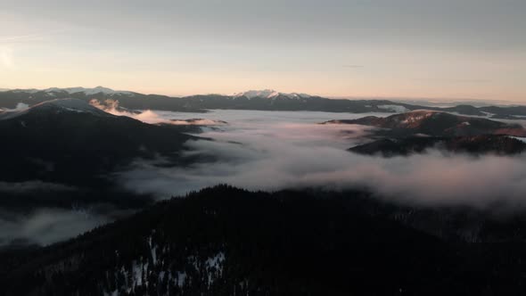 Flying Over Mountain Valley With Sea of Clouds at Sunrise