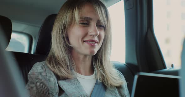 Businesswoman Making Video Chat on Smartphone Online in Back Seat of Car alt