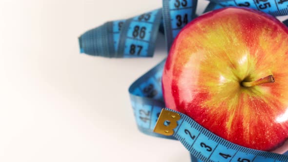 An Apple Rotates with a Centimeter Tape the Concept of Healthy Eating and Dieting for Weight Loss