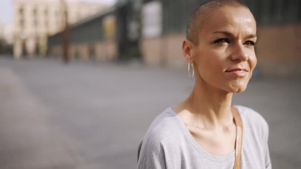 Smiling bald woman wearing t-shirt walking alt