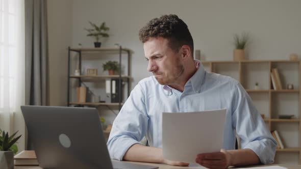 Attractive Angry Stressed Young Businessman in Shirt Sit at Desk Reading Bad Awful News in Mail alt