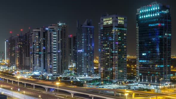 Aerial View of Jumeirah Lakes Towers Skyscrapers During All Night Timelapse with Traffic on Sheikh alt