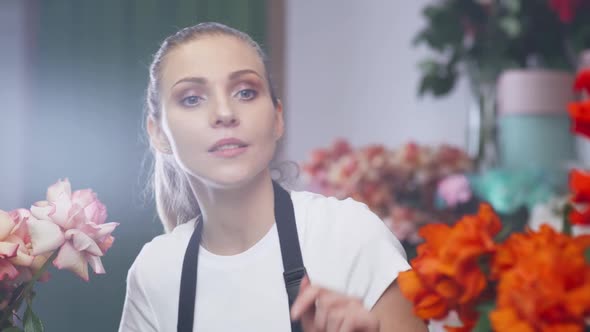 Female Florist Takes Inventory in a Flower Shop a Female Uses a Screen Tablet to Count the Number  alt