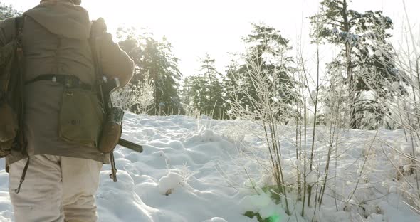 Reenactor Dressed As German Wehrmacht Infantry Soldier In World War II Walking With Weapon In Winter alt