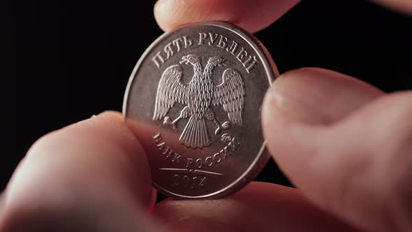 Fingers Hold Coin of 5 Russian Ruble and Turn It Over alt