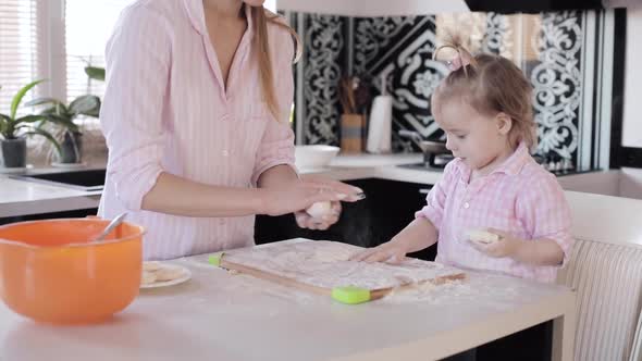 Mother Cooking Together with Little Daughter at Kitchen