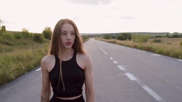 Happy Sports Girl Walks on the Main Road During Morning Workout at Nature alt