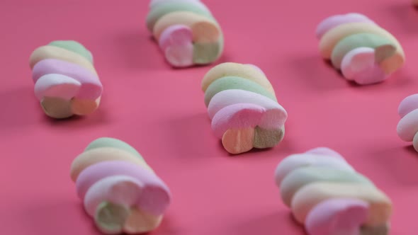 Rotating Multicolored Chewy Marshmallows on a Pink Background the Concept of a Birthday Holiday Fun