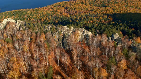 A Rock with an Autumn Forest on the Slopes alt