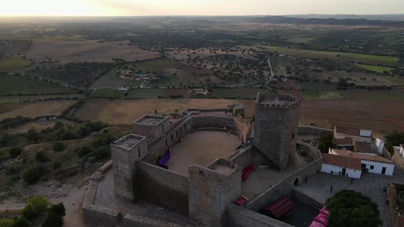 Aerial forward over Monsaraz medieval castle and surrounding countryside at dusk, Portugal alt