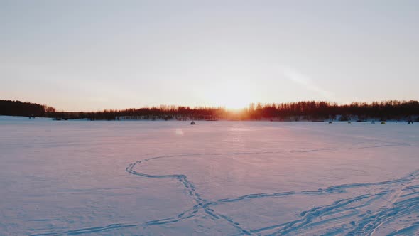 Winter Landscape View of Frozen Lake with Camping on Ice at Sunset alt