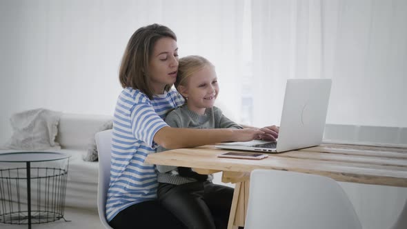 Mother working from home with daughter alt