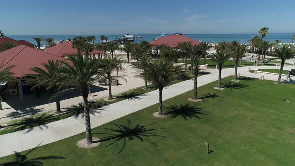 Aerial view of palm trees and pavilions on a beach alt