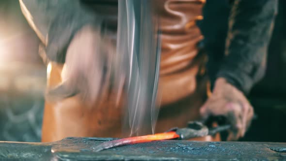 Person Shapes a Hot Knife, Using a Hammer on Anvil alt