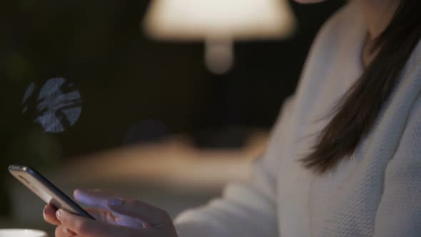 Young Bored Woman Swiping Pages on Smartphone and Drinking Tea in Cafe alt