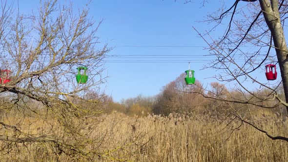 Green cableway cabins moving to each other in sky