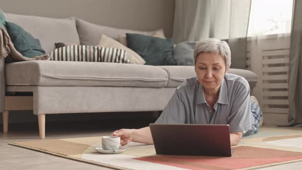 Woman with Laptop Lying on Floor alt