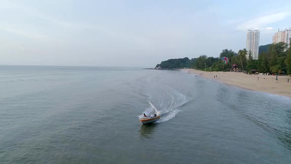 A slowmo shot of a boat driver preparing a landing of a Parasailer in Penang, Malaysia. alt