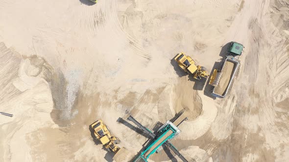 Heavy equipment machine wheel loader on sand mine. bulldozer loading sand. Aerial view alt