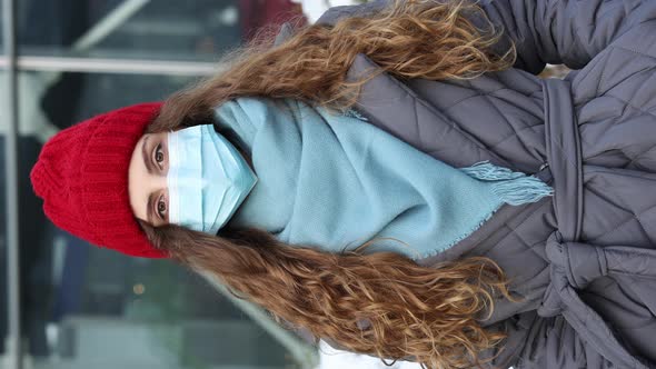 Vertical Shot of Portrait of Young Curly Female in Medical Face Mask Standing on Street