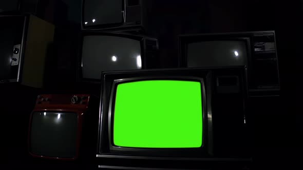 Retro TV Set Turning On Green Screen on a Pile of Retro TV. Zoom In. 4K Version.