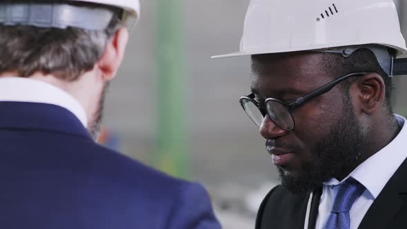 African American engineer staying in helmet