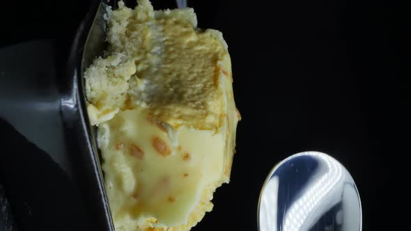 Delicate Mousse Cake in Yellow Icing with Banana Flavor on a Black Background alt