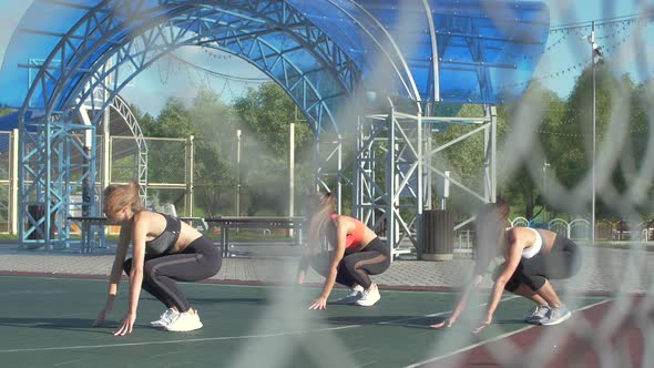 Group of women working out outdoors. Training and doing exercises alt