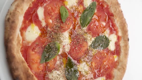Vertical video: Pizza sprinkled with Italian spices alt