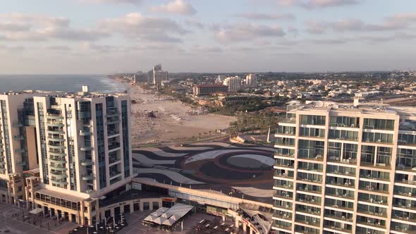 A flight between high points to the sea with the beach and tourists in the town of Herzelia in Israe alt